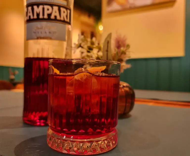 Fles Campari en een Negroni-cocktail op tafel bij La Torre in Lier, een perfecte Italiaanse aperitief